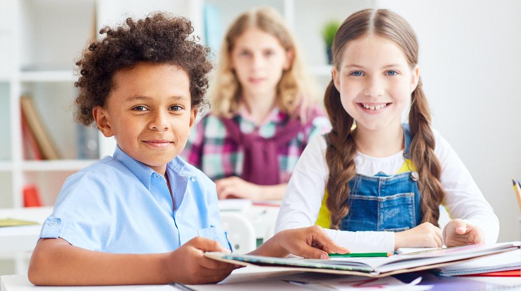 crianças na escola, com livro na mão com dificuldade de aprendizagem